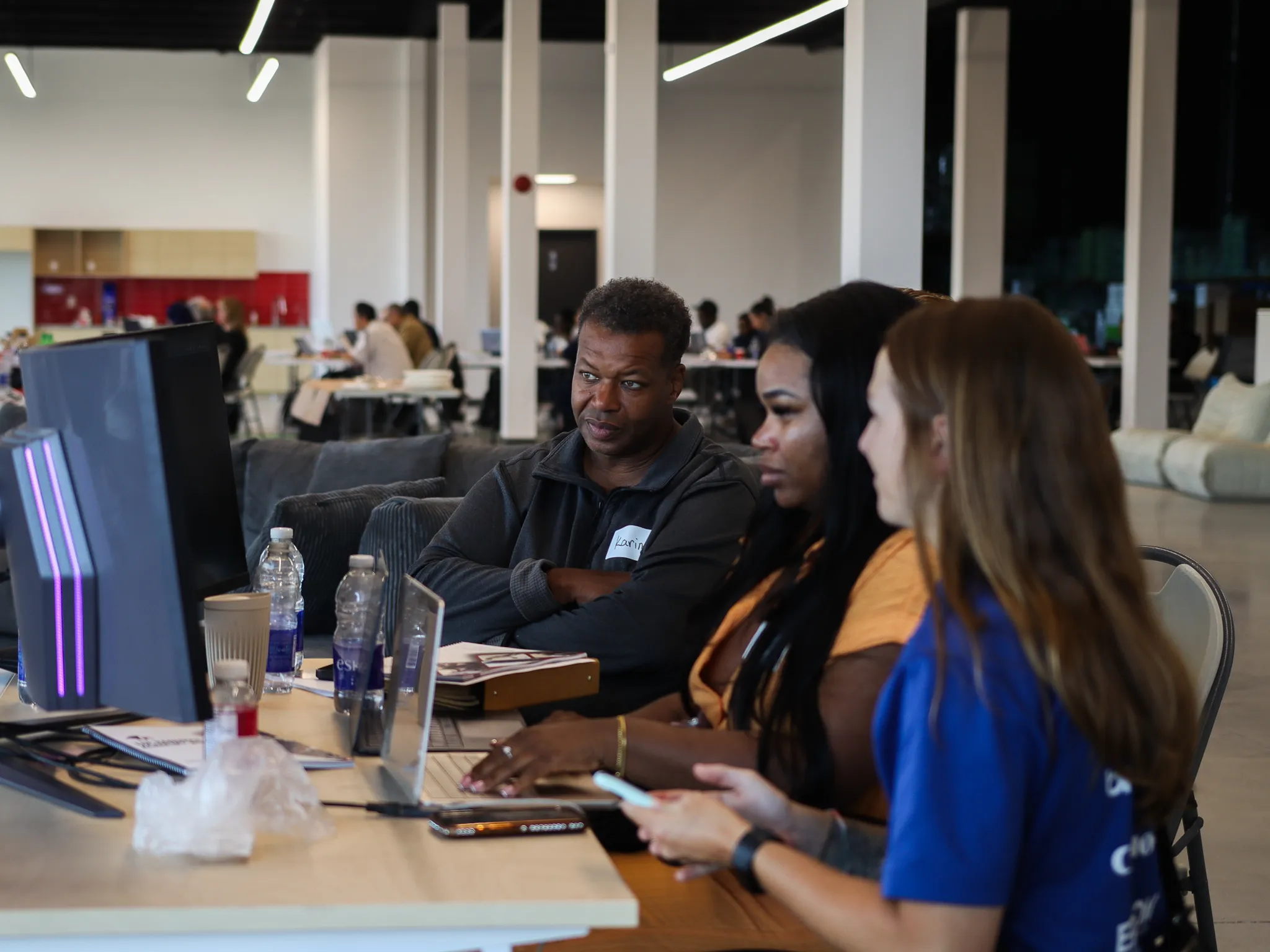 Three people working at computers during a Randmar event