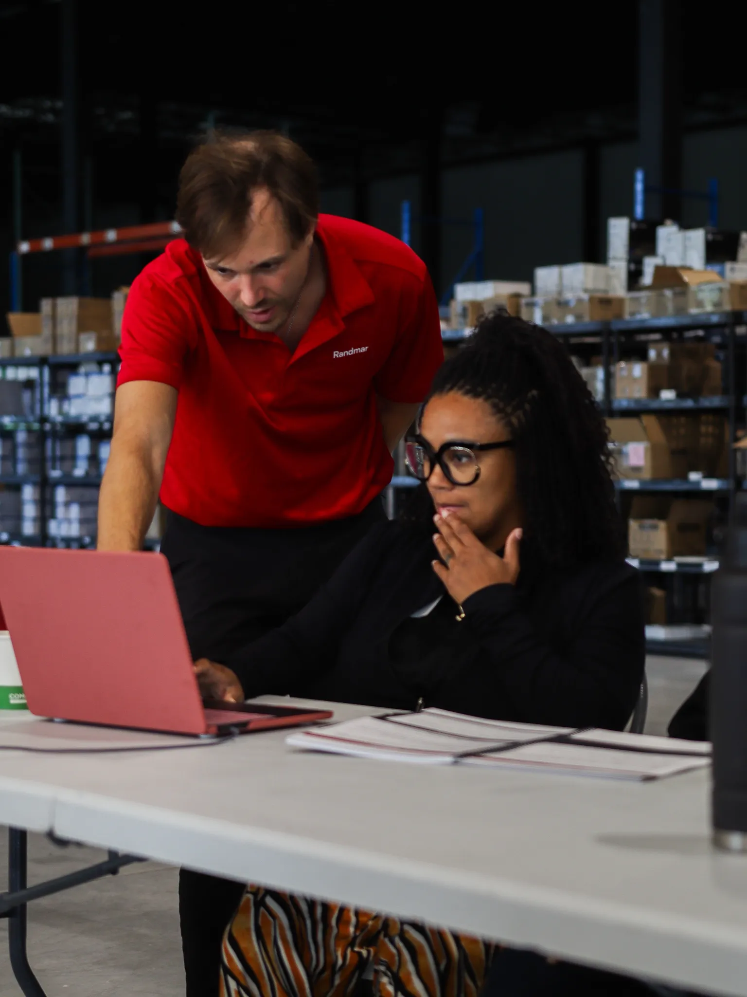 A Randmar presenter helping a participant at a laptop