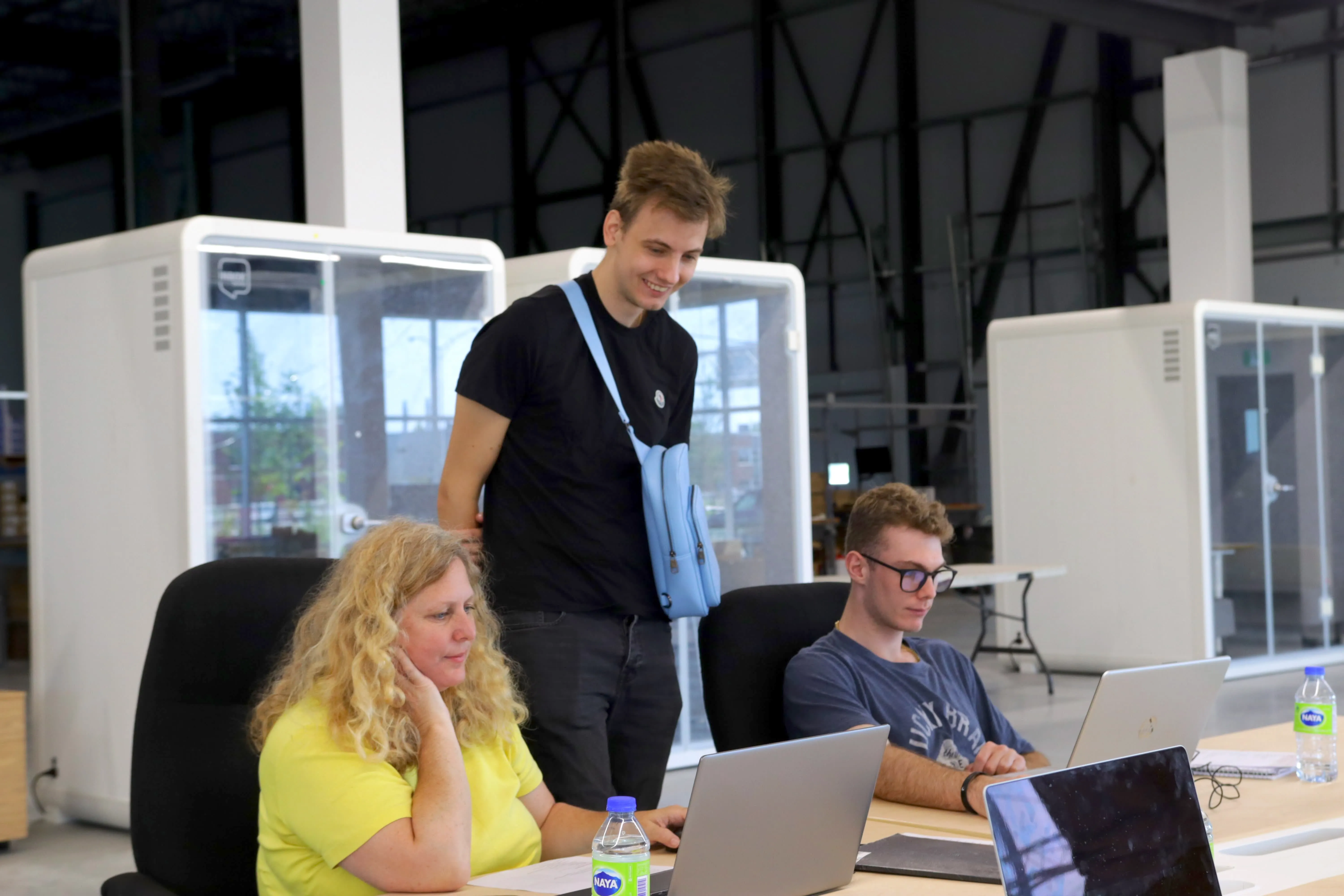 A facilitator and participants reviewing laptops together at a Randmar event